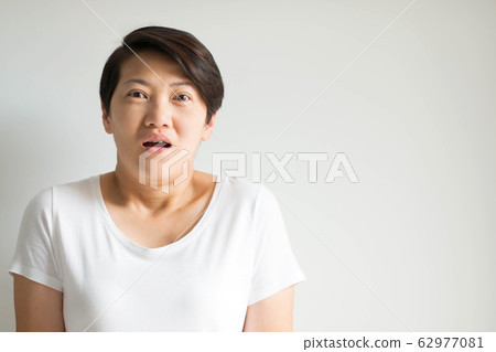 A woman portrait in an expression of stunned, frightened and panic on white background. A woman portrait in an expression of stunned, frightened and panic on white background. 62977081