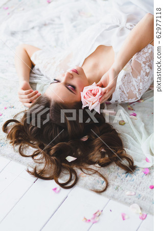 Close-up portrait of young beautiful model with rose 62977118
