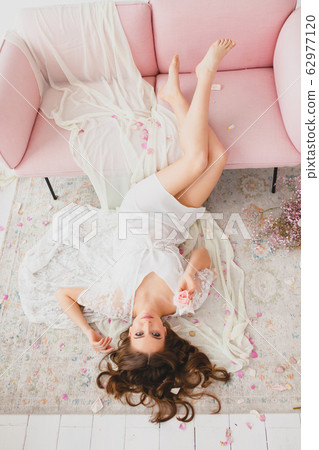 Young bride with beautiful naked legs posing on a floor in the big white studio 62977120