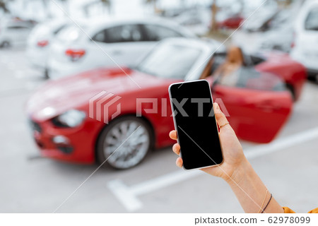 Holding smartphone at the car parking 62978099