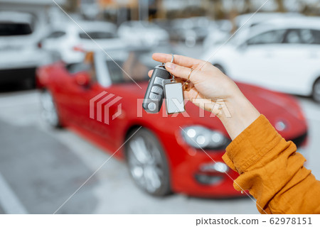 Woman holding keychain at the car parking Woman holding keychain at the car parking 62978151