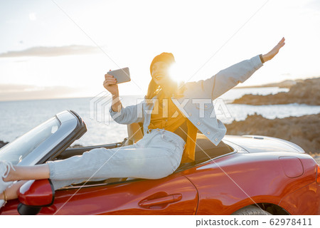Woman vlogging on phone while travel on the ocean coast 62978411