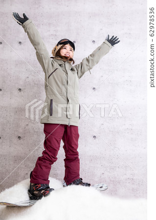 A woman snowboarding 62978536