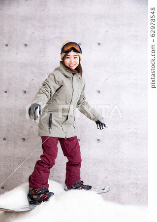 A woman snowboarding 62978548