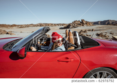 Woman traveling by cabriolet car on the desert velley 62978792