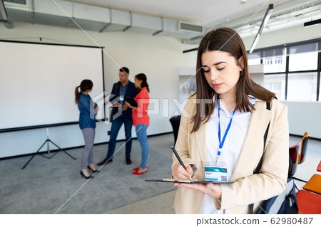 Businesswoman taking notes in a office 62980487