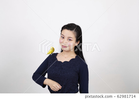 Smiling young woman playing with a swaddling in front of a white background Smiling young woman playing with a swaddling in front of a white background 62981714
