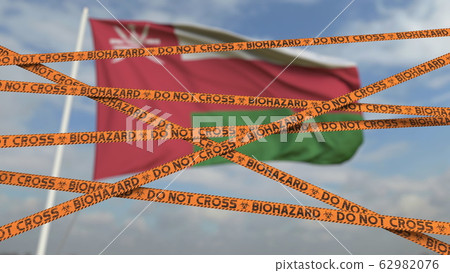 Biohazard restriction tape lines against the Omani flag. Restricted entry or quarantine in Oman. Conceptual 3D rendering 62982076
