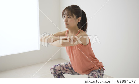 Muscular training young woman squat 62984178