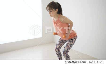 Young woman doing muscle training @ rowing 62984179