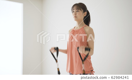 Young woman doing muscle training @ shoulder raise 62984241