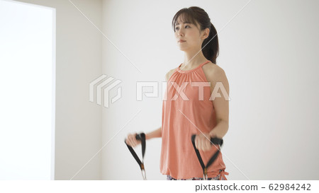 Young woman doing muscle training @ shoulder raise 62984242