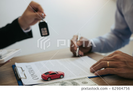 New car buyers sign contract documents for new car 62984756