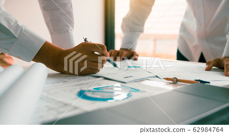 Engineering man showing blueprint detail for Engineering man showing blueprint detail for 62984764