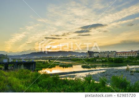 在河面上，太陽在天際線升起，而宮彩彩（Aya Miyabi）在水面上反射。 62985720