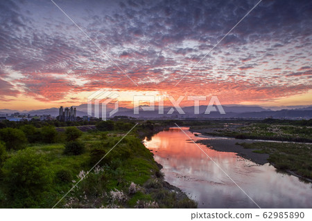 在河面上,太陽在天際線升起,而宮彩彩(Aya Miyabi)在水面上反射。 在河面上,太陽在天際線升起,而宮彩彩(Aya Miyabi)在水面上反射。 62985890