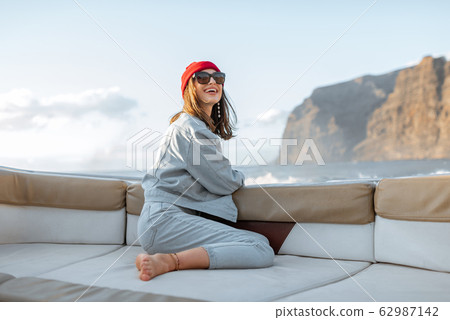 Woman traveling on a yacht near the rocky coast 62987142