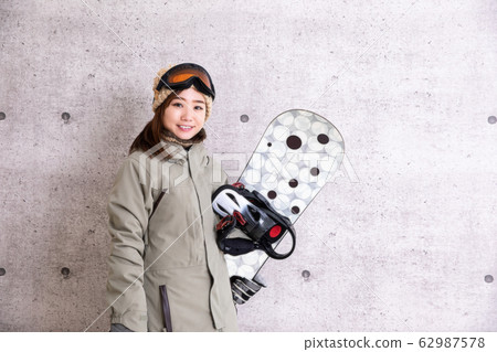 A woman snowboarding 62987578