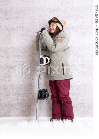 A woman snowboarding 62987916