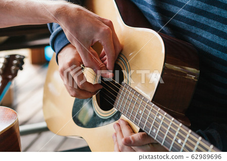 Learning to play the guitar. 62989696