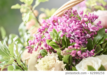 Spring bouquet in a wicker basket.. Learning flower arranging, making beautiful bouquets with your own hands. Flowers delivery 62990258