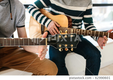 Learning to play the guitar. Learning to play the guitar. 62990601