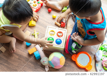 Group of children playing together with wooden toy 62991197