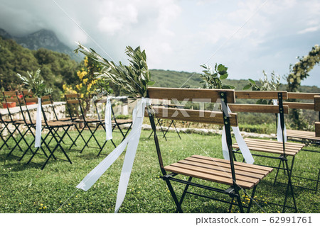 Decorated chairs at a wedding event. Decorated chairs at a wedding event. 62991761