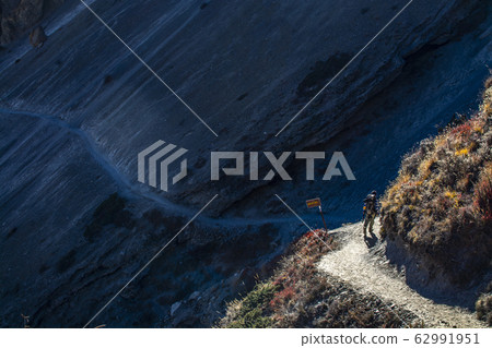 Trekker walking on mountain with mountains Trekker walking on mountain with mountains 62991951
