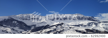 Panorama of high snowy mountains and blue sky with Panorama of high snowy mountains and blue sky with 62992400