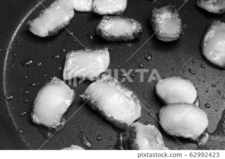 Slices of bacon frying in its own grease on frypan Slices of bacon frying in its own grease on frypan 62992423
