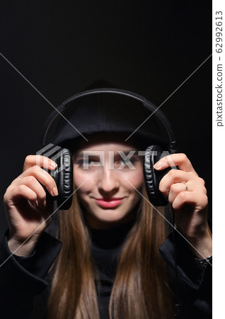 Girl In Hoodie Holding Headphones 62992613