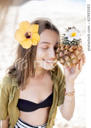 Summer girl with pineapple fruit at the beach resort Summer girl with pineapple fruit at the beach resort 62993083