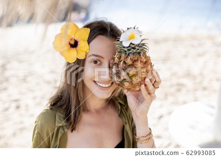 Summer girl with pineapple fruit at the beach resort 62993085