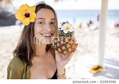 Summer girl with pineapple fruit at the beach resort Summer girl with pineapple fruit at the beach resort 62993086