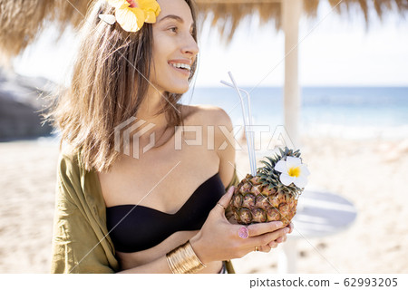 Woman with exotic cocktail at the beach resort Woman with exotic cocktail at the beach resort 62993205