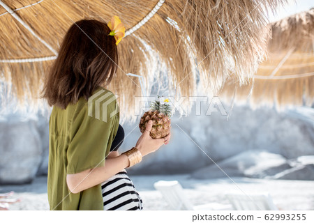 Woman with exotic cocktail at the beach resort 62993255