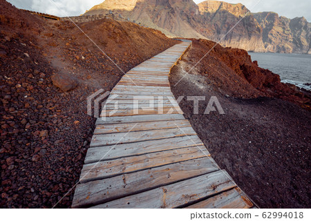Landscape with picturesque wooden pathway through the rocky land 62994018