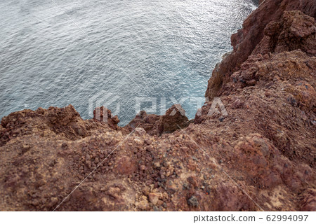 Rocky ocean coast with steep precipice 62994097