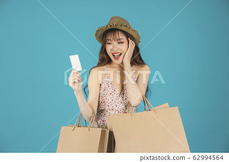 Asian girl carrying shopping bags with summer dress and enjoys shopping. Asian girl carrying shopping bags with summer dress and enjoys shopping. 62994564