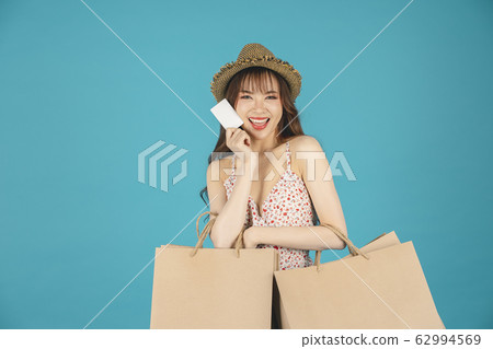 Asian girl carrying shopping bags with summer dress and enjoys shopping. Asian girl carrying shopping bags with summer dress and enjoys shopping. 62994569