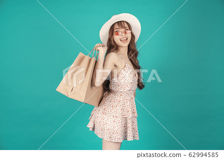 Asian girl carrying shopping bags with summer dress and enjoys shopping. Asian girl carrying shopping bags with summer dress and enjoys shopping. 62994585