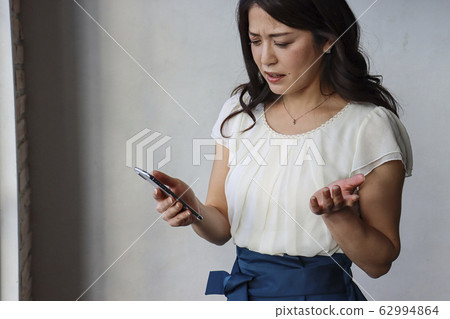 顯示帶有可疑表情的可疑電子郵件的女人 62994864