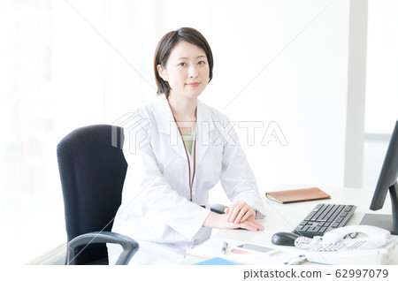 White coat woman desk work White coat woman desk work 62997079