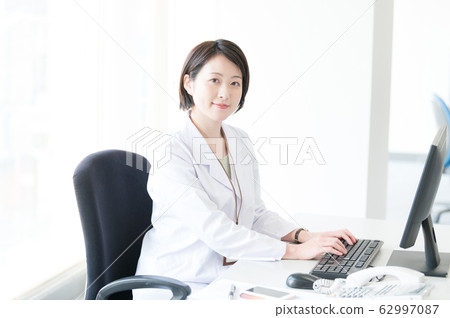 White coat woman desk work White coat woman desk work 62997087