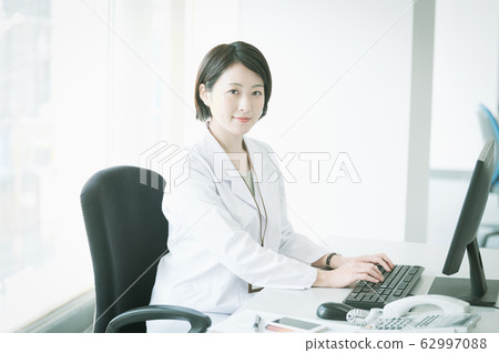 White coat woman desk work White coat woman desk work 62997088