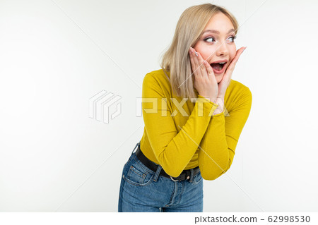 surprised joyful cute girl in a lemon turtleneck and jeans laughs on an isolated white background 62998530