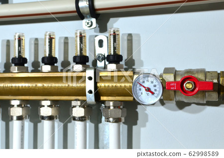 Manometer, pipe, flow meter, water pumps and valves of heating system in a boiler room at home 62998589
