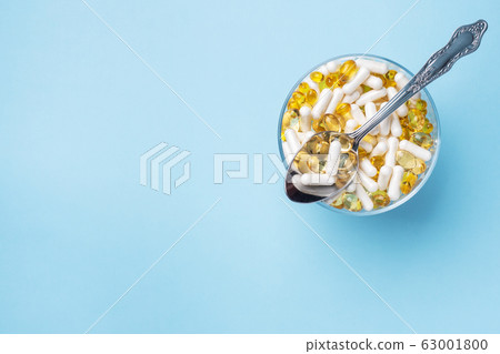 Medications vitamins tablets and pills on a plate. Medications vitamins tablets and pills on a plate. 63001800
