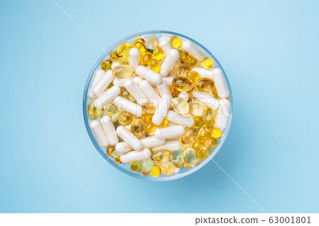 Medications vitamins tablets and pills on a plate. Medications vitamins tablets and pills on a plate. 63001801